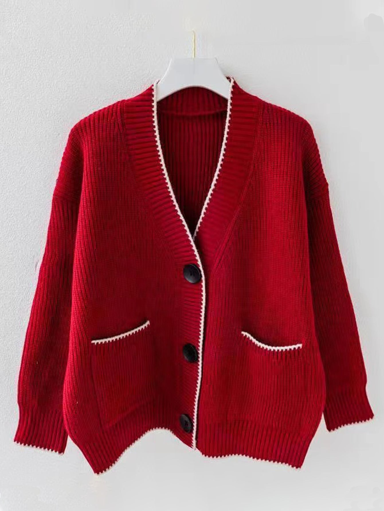 Women's chunky knit cardigan with deep V-neck and practical pockets. Chic and stylish.
