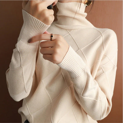 Eine Frau trägt einen beige Rollkragenpullover