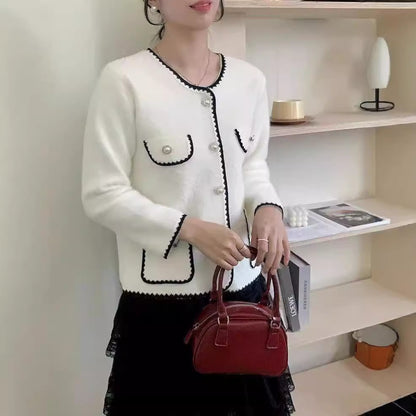 Ladies' Elegant knitted vest with pearl-embellished pockets and feminine accents. Chic and stylish.