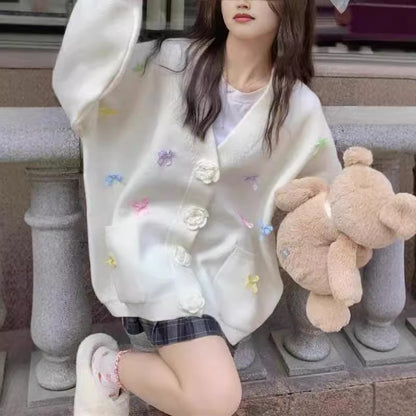 Dames cardigan avec des applications de fleurs ludiques et de grands boutons Chic und Stil