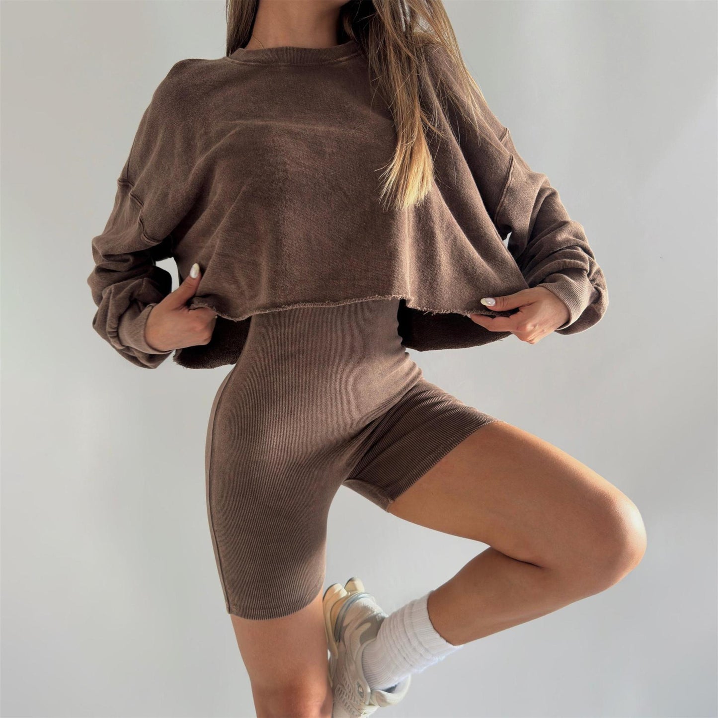 Women's outfit consisting of a cropped sweatshirt and chic cycling shorts und style