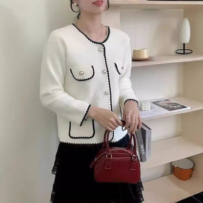 Ladies' Elegant knitted vest with pearl-embellished pockets and feminine accents. Chic and stylish.