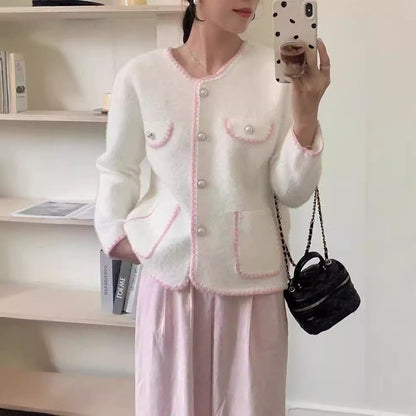 Ladies' Elegant knitted vest with pearl-embellished pockets and feminine accents. Chic and stylish.