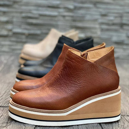 Nahaufnahme von braunen orthopädischen Stiefeletten im Vordergrund, mit leicht verschwommenen Farben anderer Stiefel im Hintergrund.